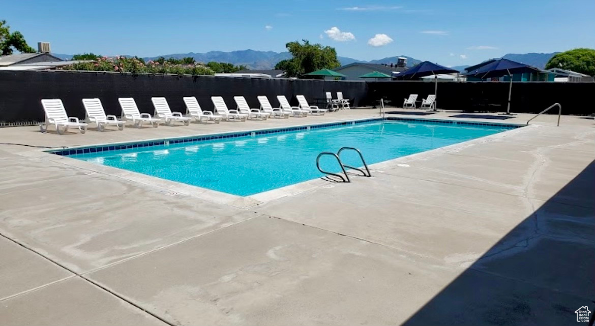 View of swimming pool with a mountain view and a patio area