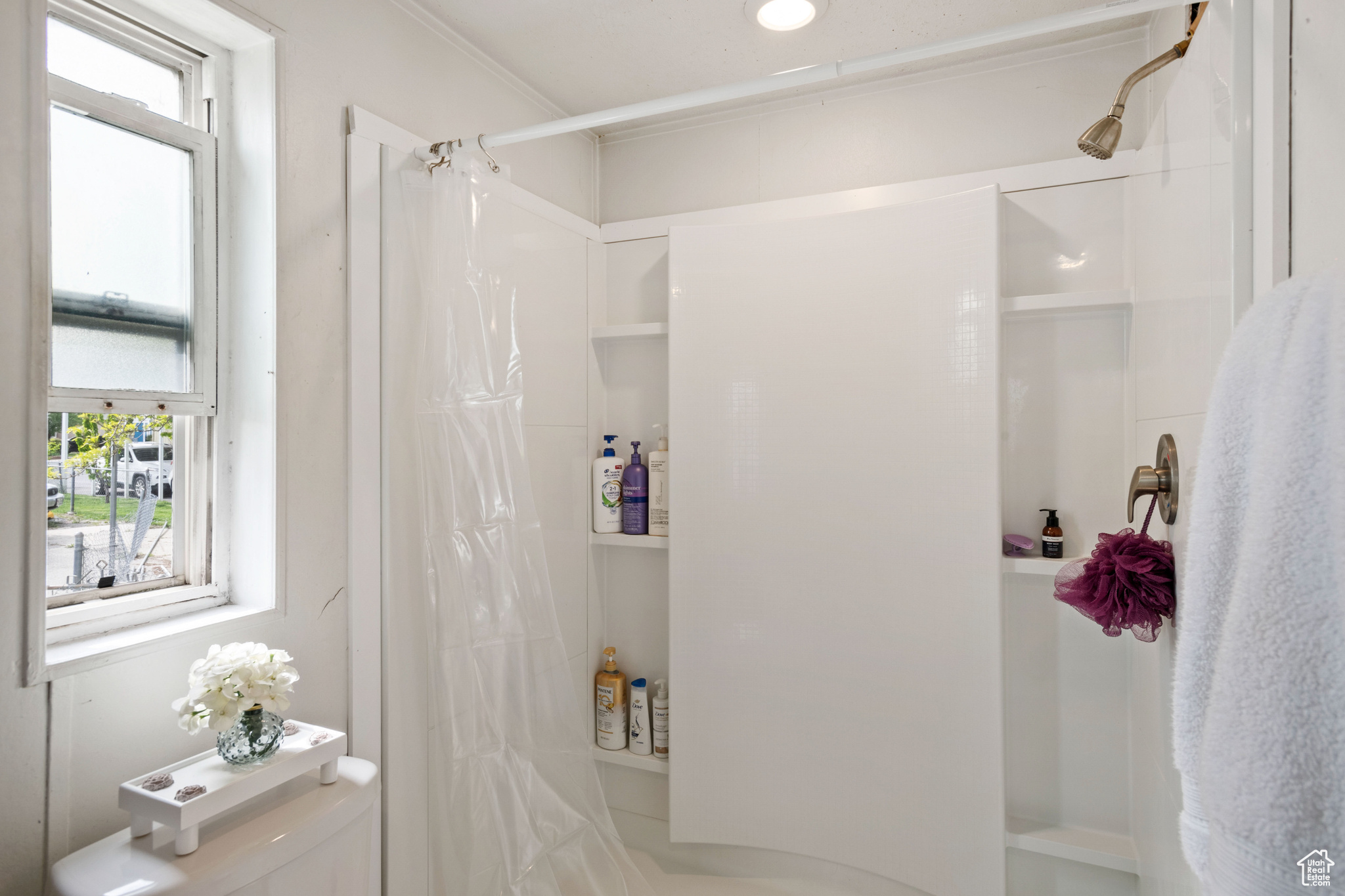 Bathroom featuring curtained shower, crown molding, and tile flooring