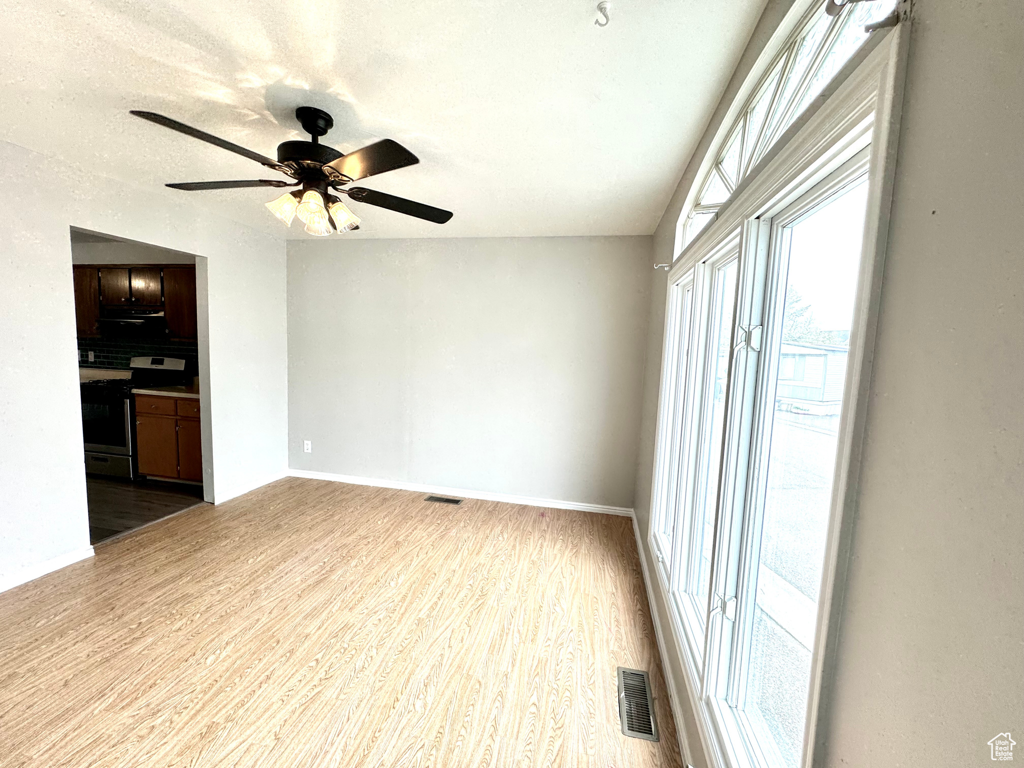 Primary Suite hardwood / wood-style floors and ceiling fan
