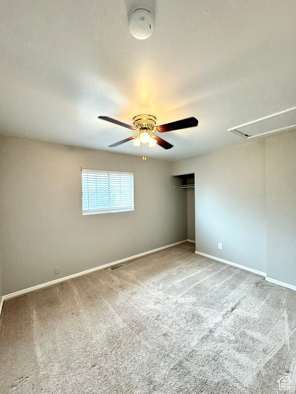 Carpeted bedroom room featuring carpet and ceiling fan