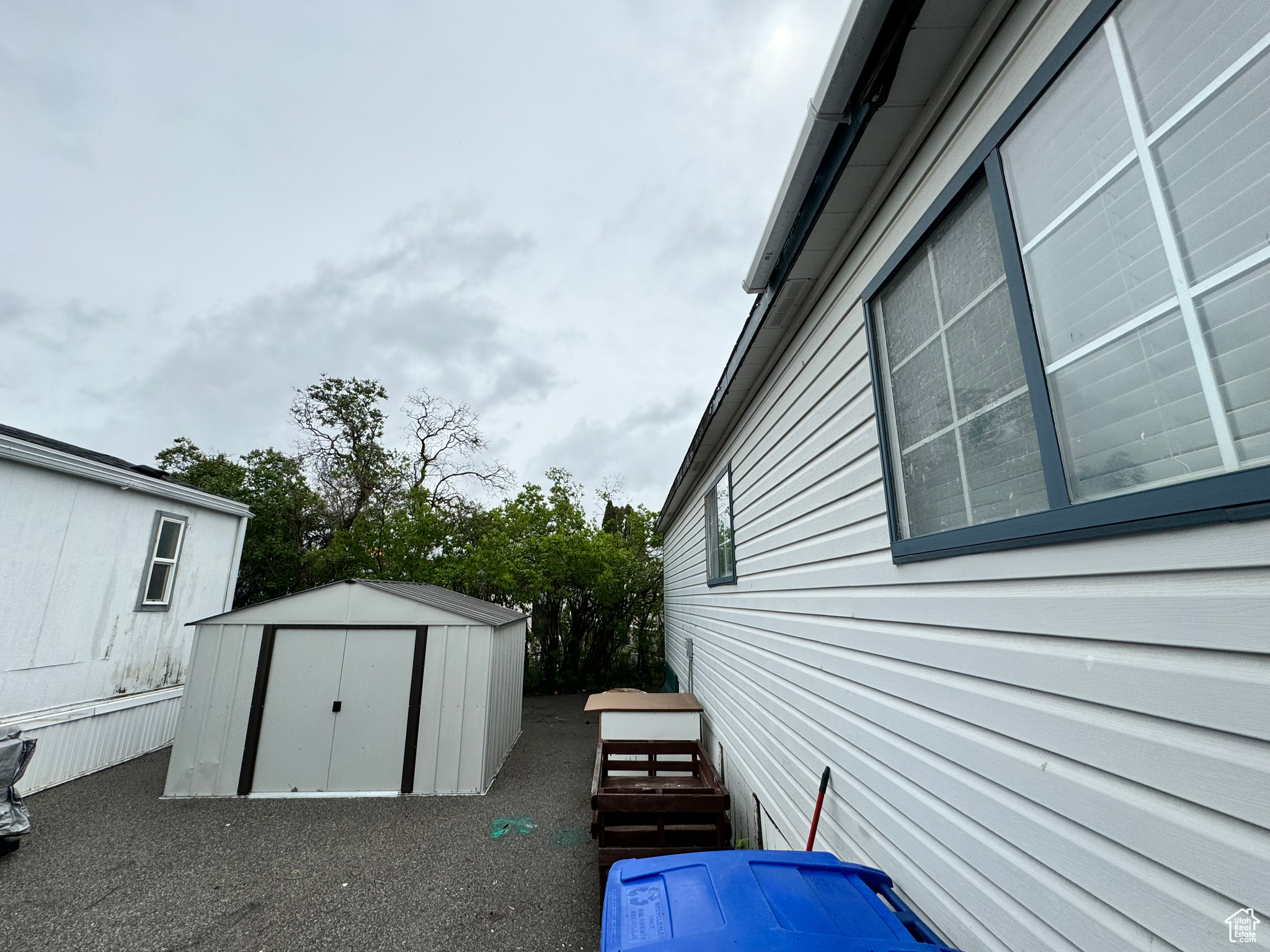 View of property exterior featuring a storage shed which is included in the sale of the mobile home.