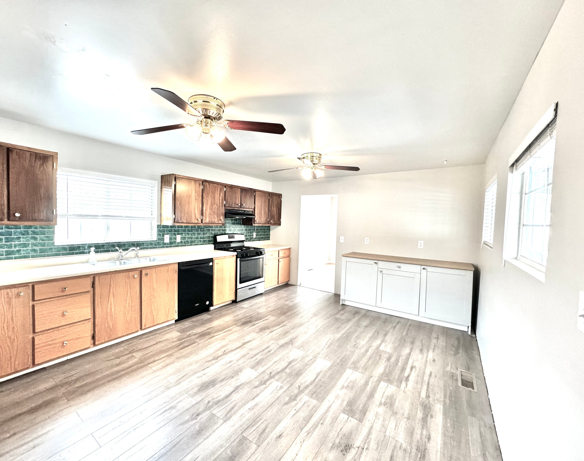 Kitchen with gas stove, light hardwood / wood-style floors, dishwasher, and ceiling fan