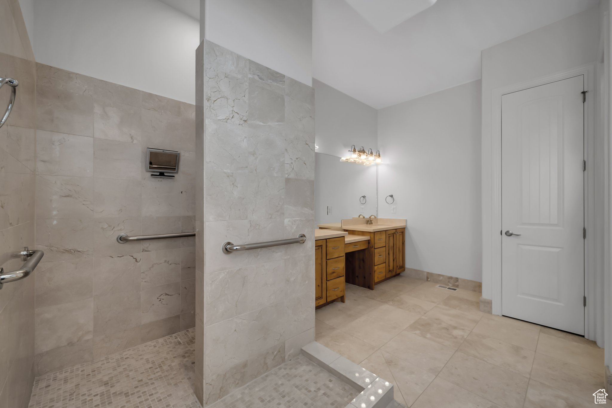Bathroom featuring vanity, tile floors, and tiled shower