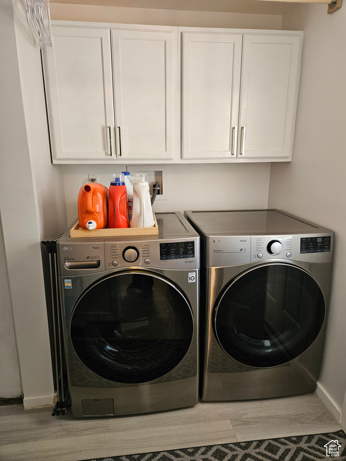 Laundry area featuring cabinets, independent washer and dryer, light hardwood / wood-style floors, and washer hookup