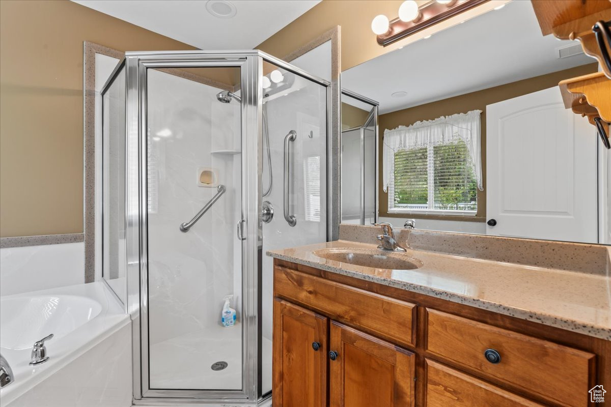 Bathroom featuring separate shower and tub and large vanity