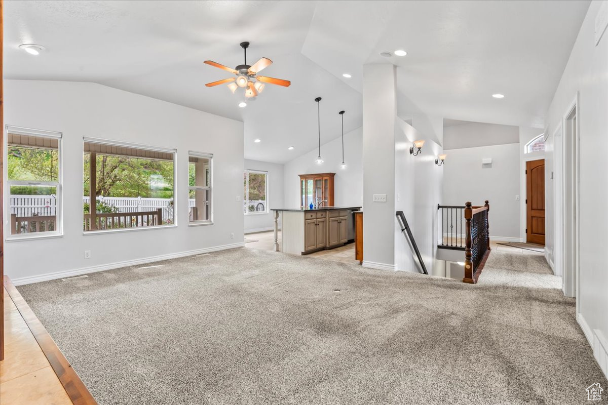 Unfurnished living room featuring high vaulted ceiling, ceiling fan, and light tile flooring