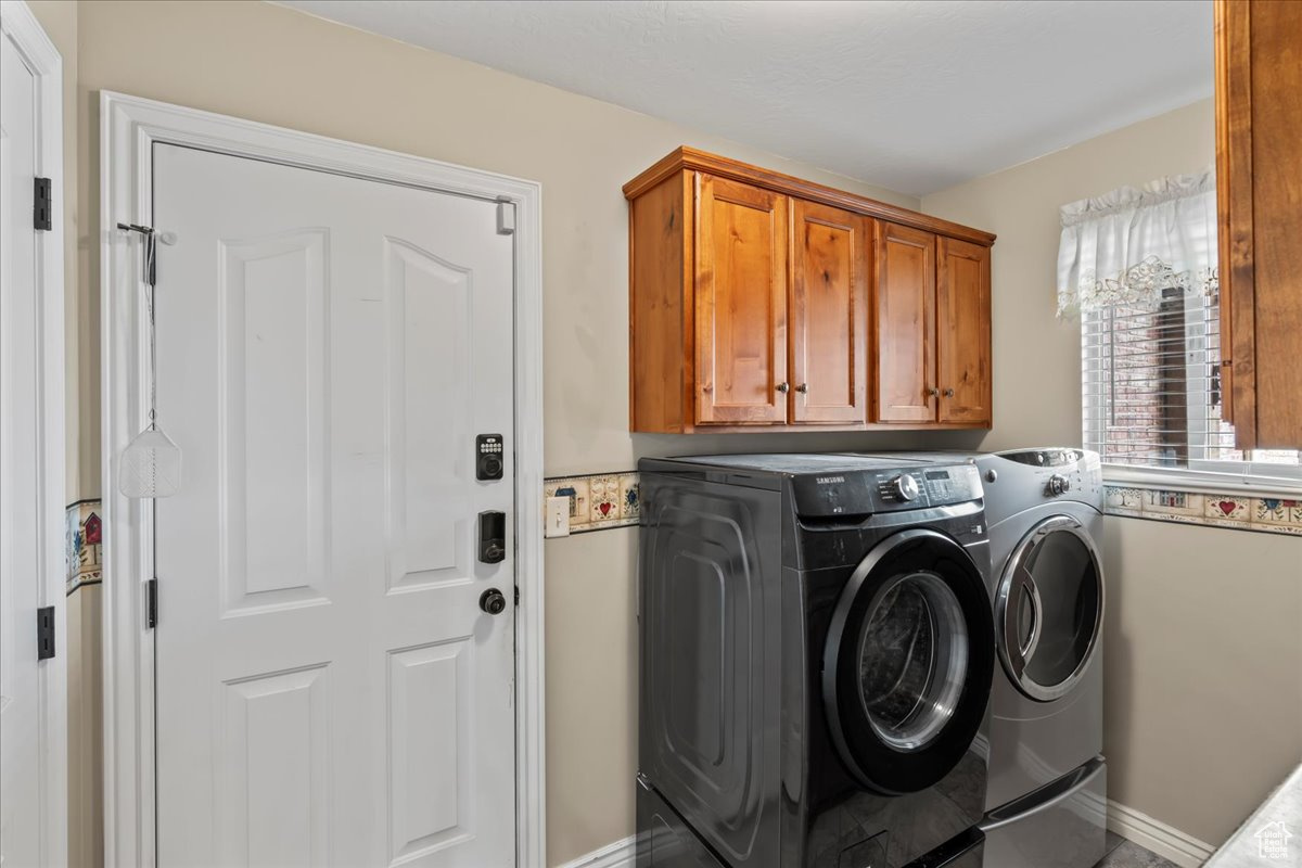 Laundry room featuring cabinets and washing machine and dryer