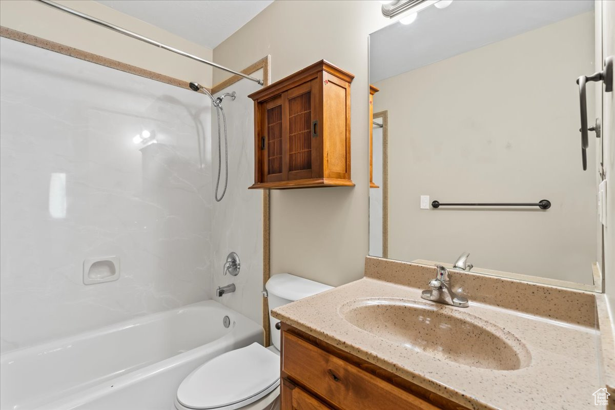 Full bathroom with oversized vanity, toilet, and shower / washtub combination