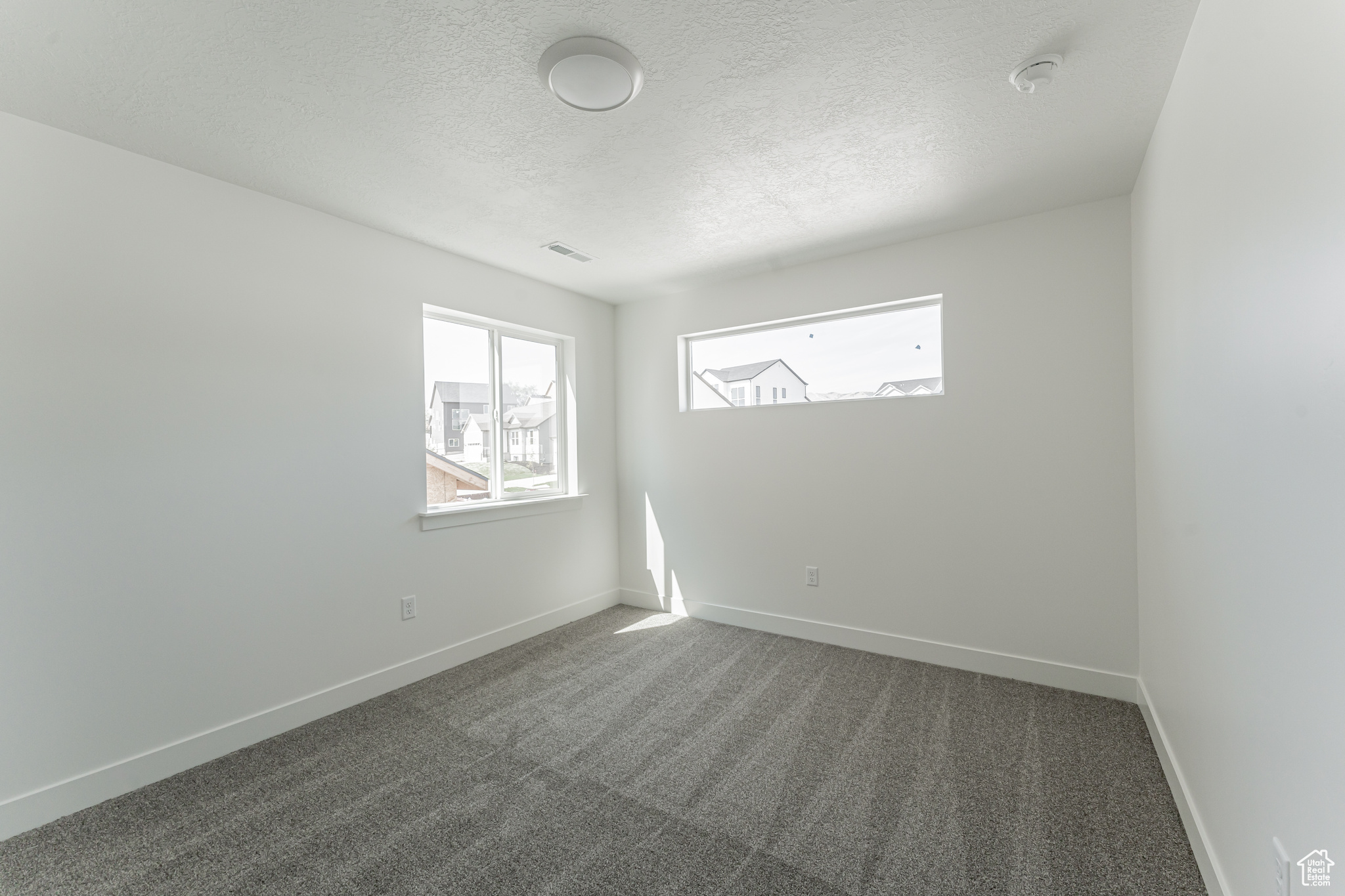 Spare room with a textured ceiling and carpet