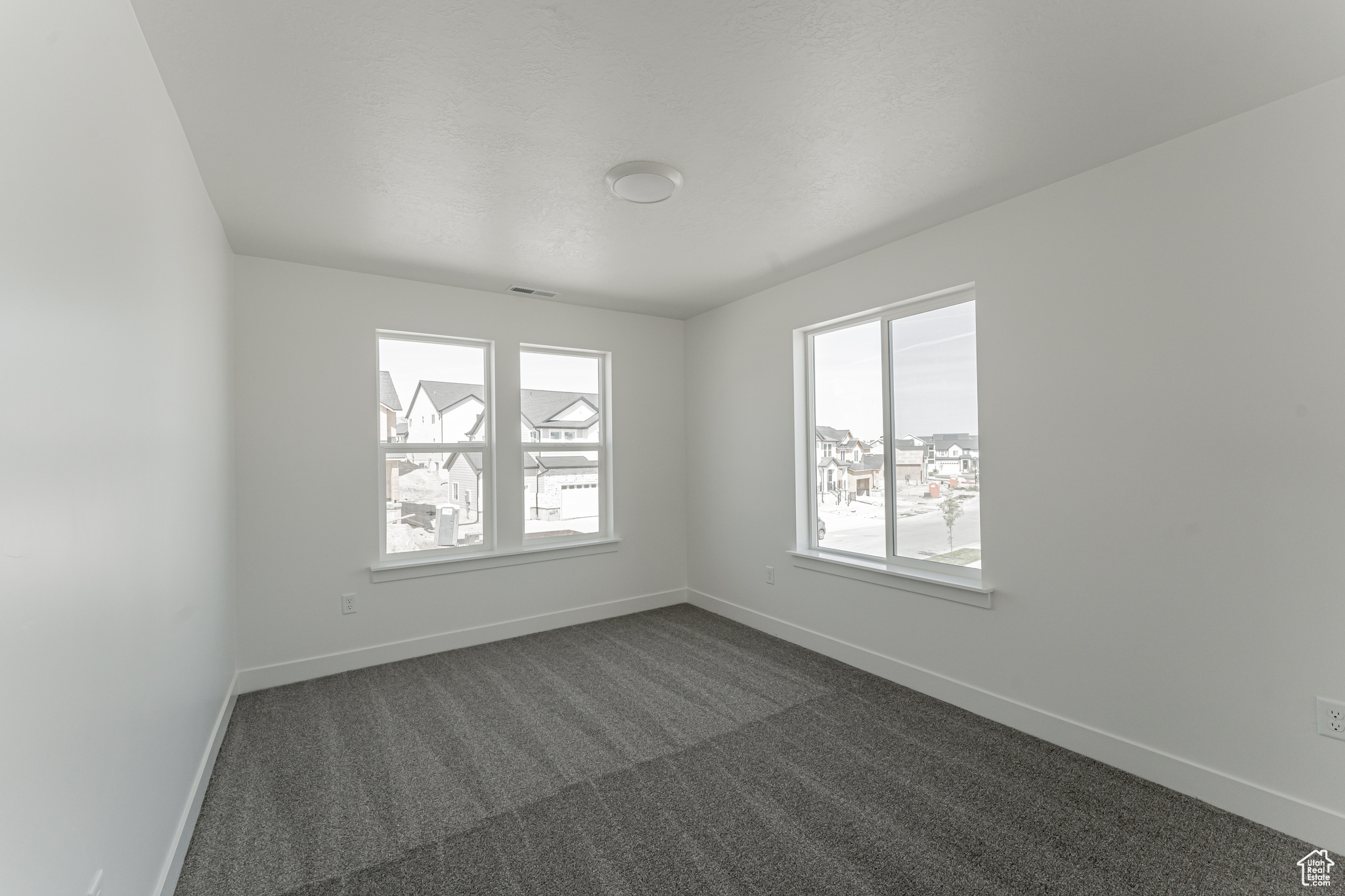 Unfurnished room featuring dark carpet