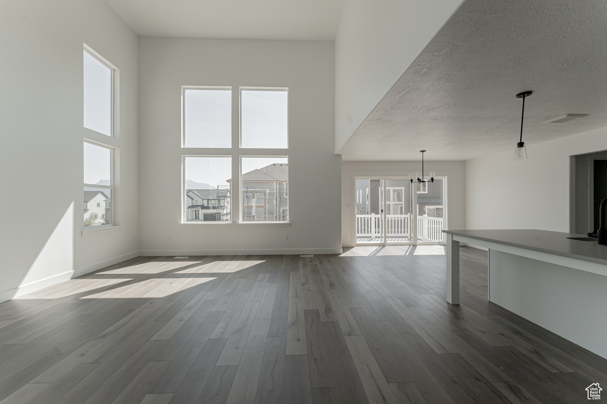 Unfurnished living room with dark hardwood / wood-style floors, a chandelier, and a textured ceiling