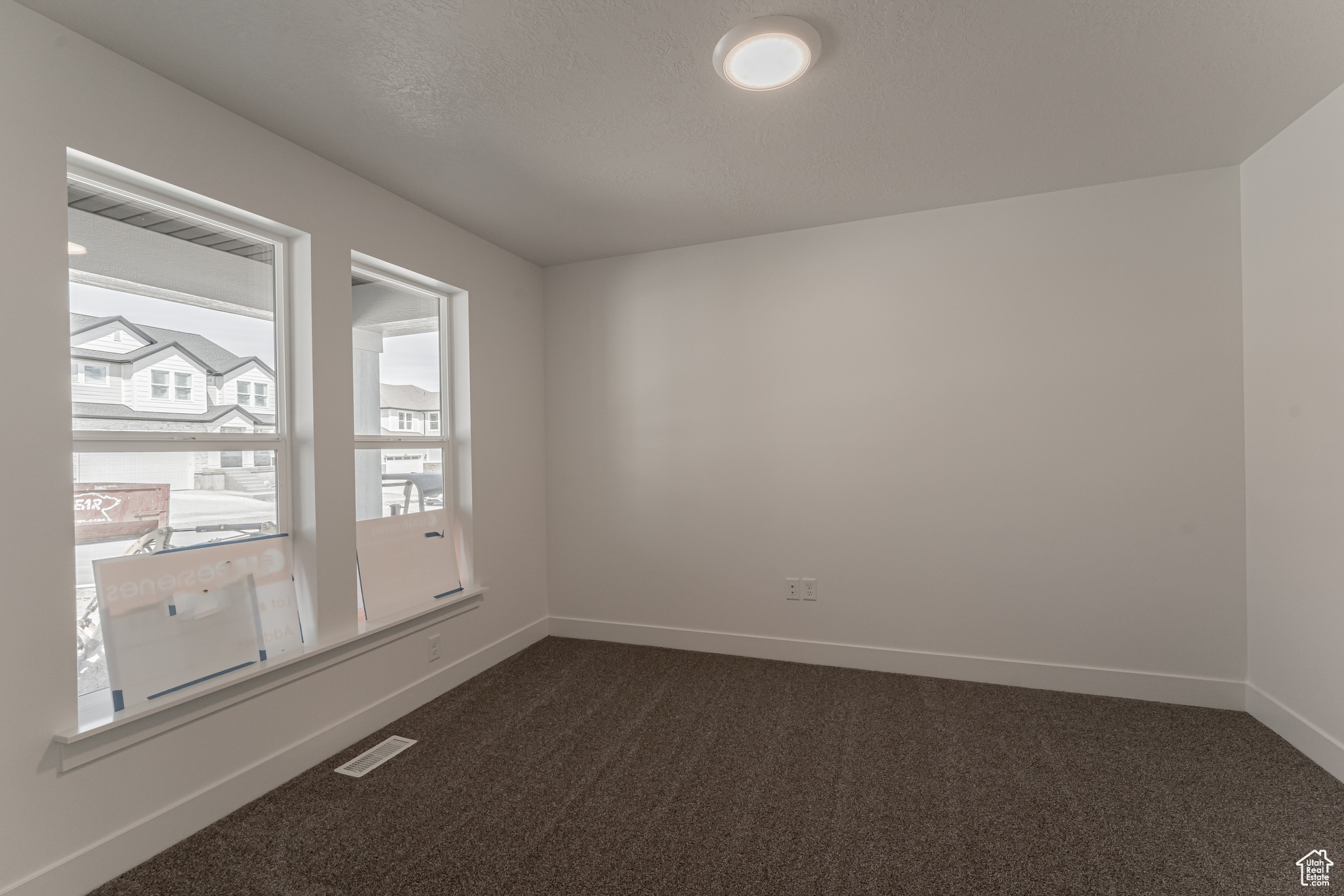 Carpeted empty room with a textured ceiling