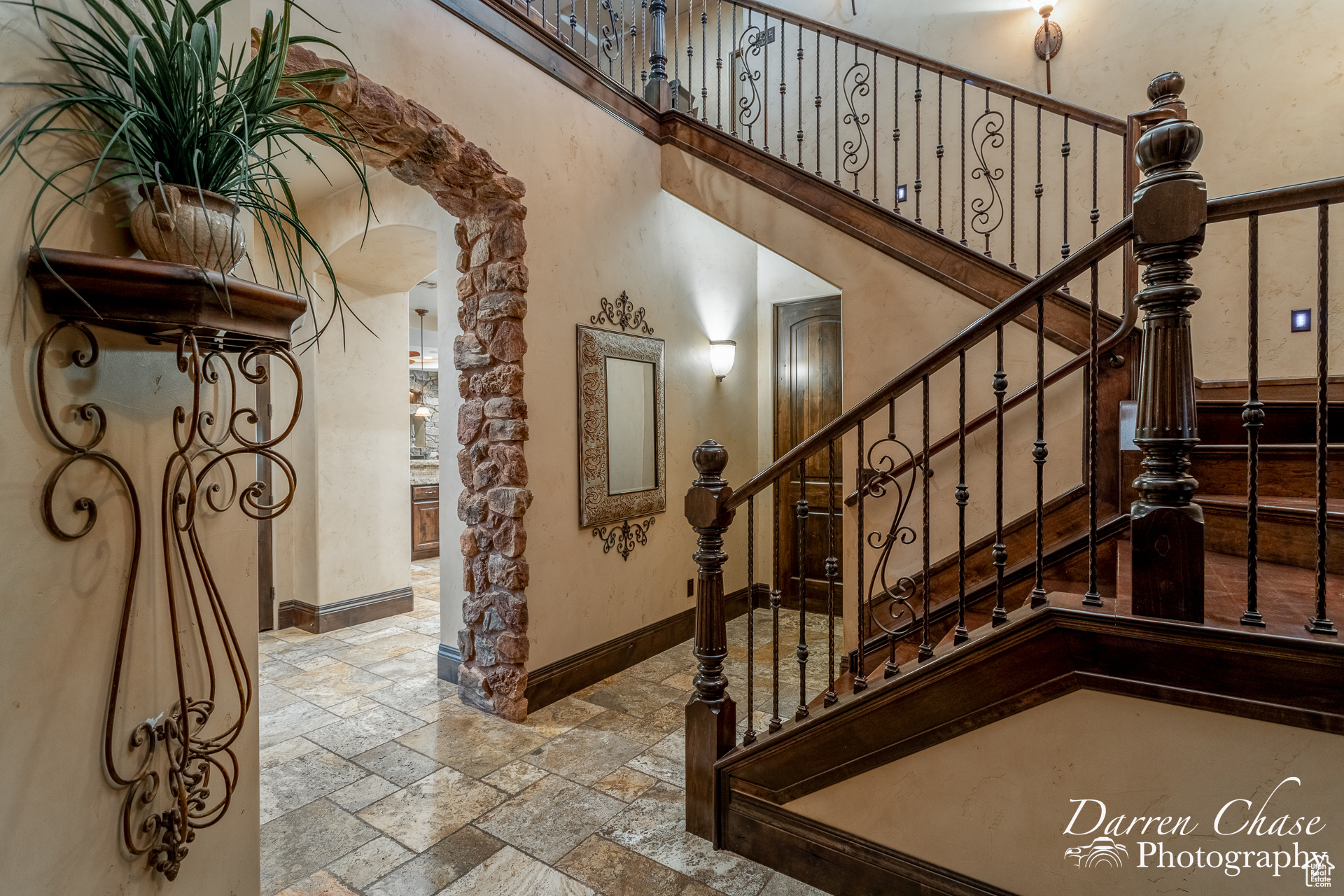 Stairway with light tile flooring and a towering ceiling