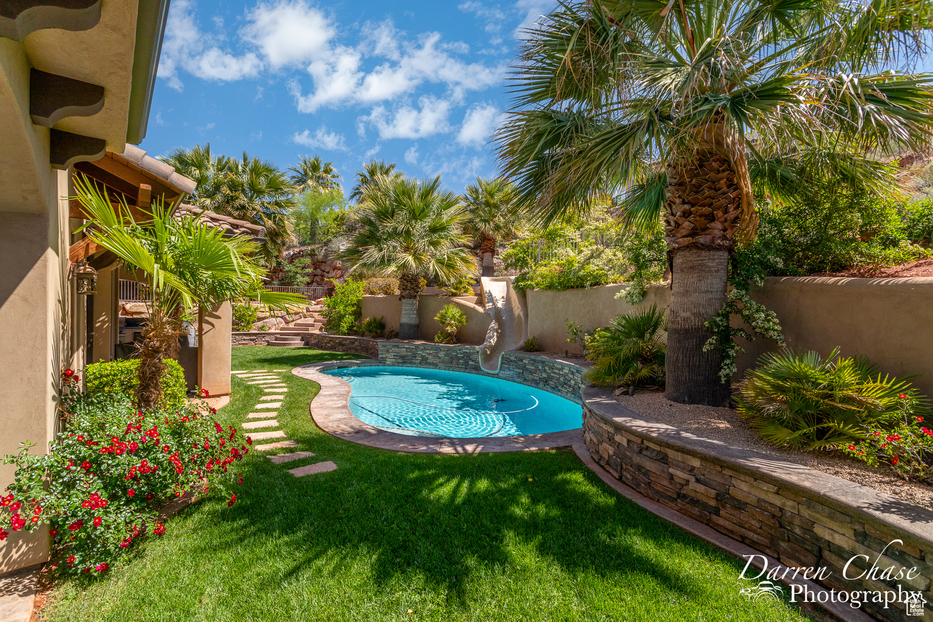 View of swimming pool with a lawn and a water slide