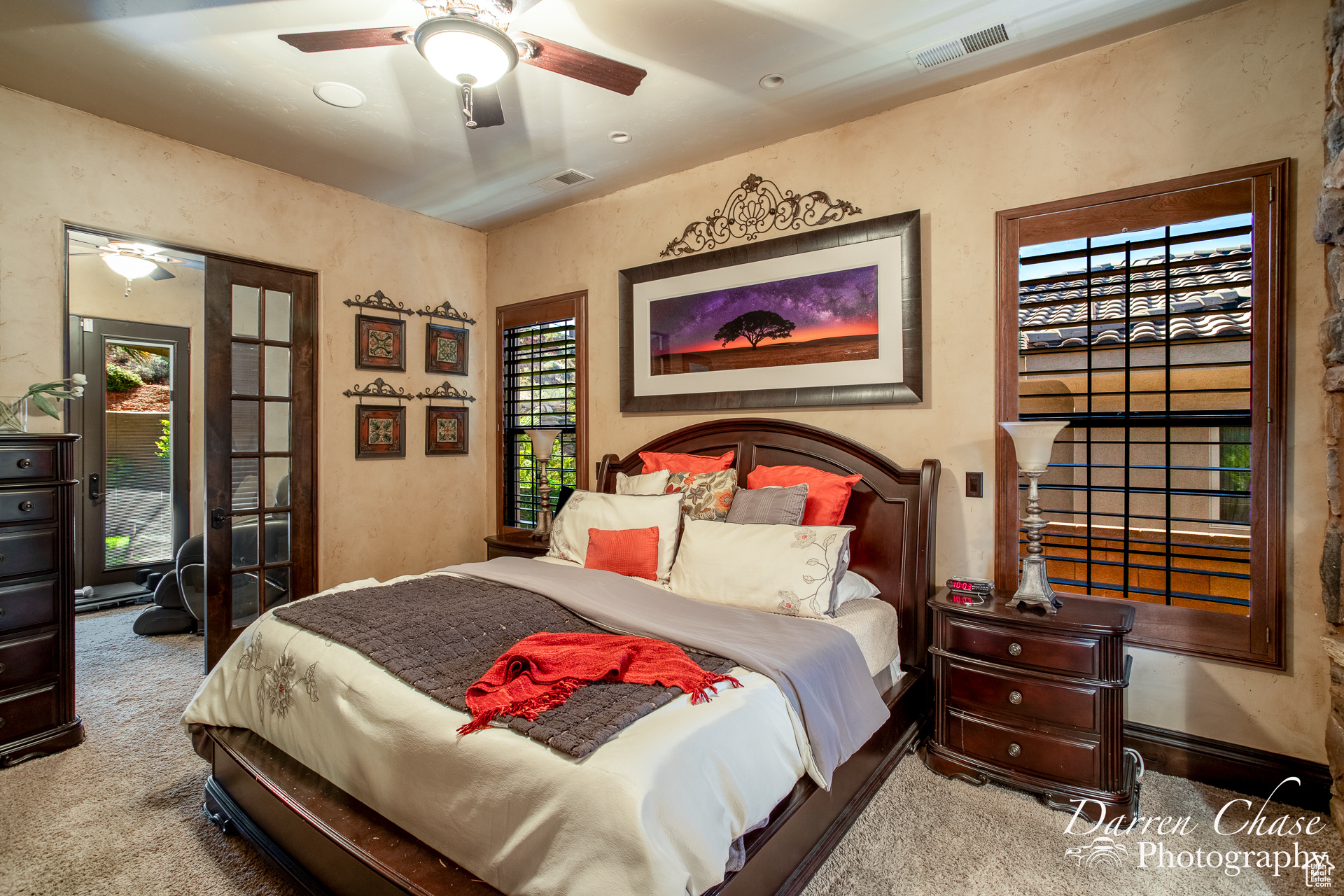 Primary bedroom with ceiling fan and carpet flooring