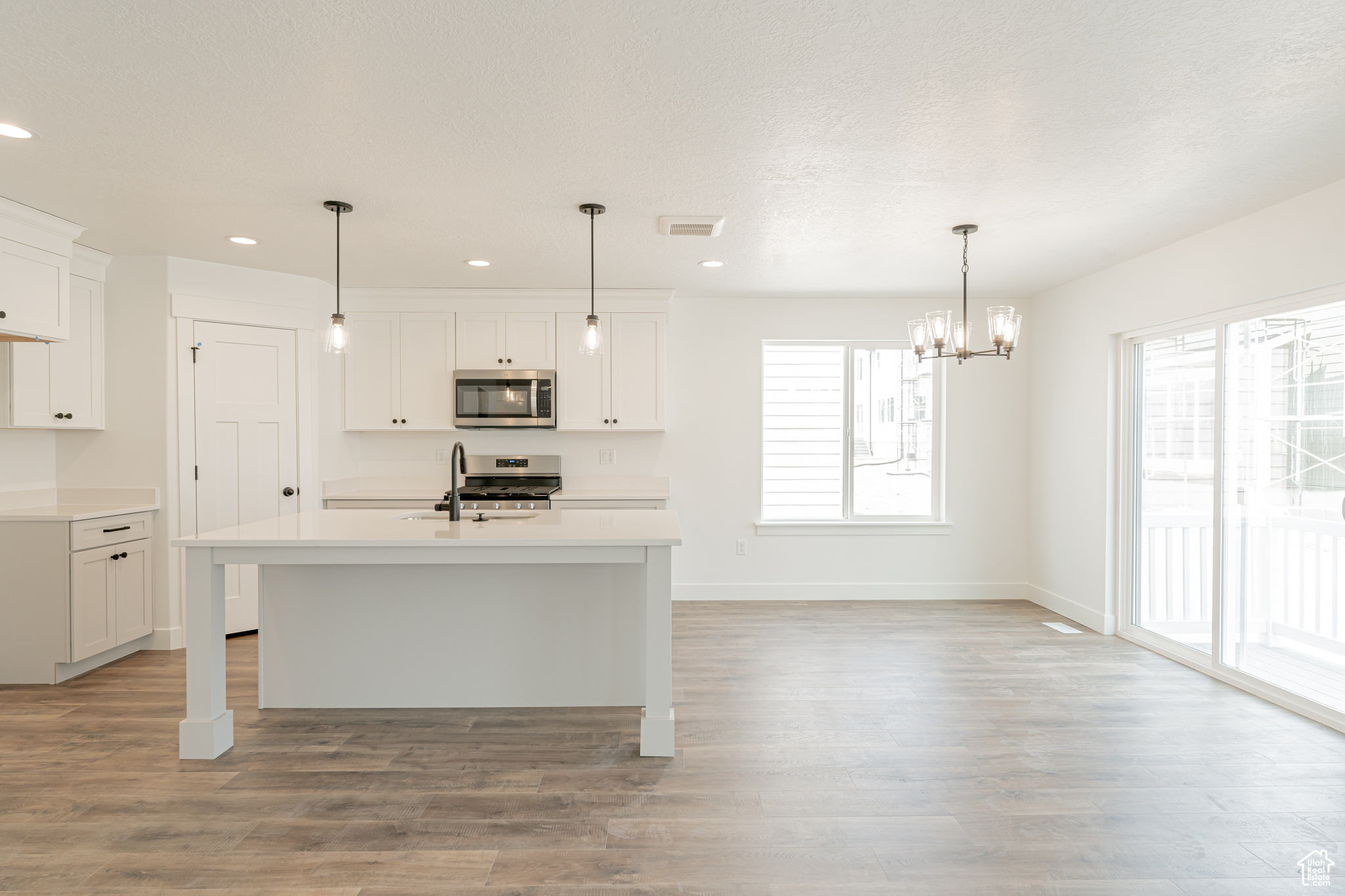 Kitchen featuring white cabinetry, light hardwood / wood-style flooring, sink, and plenty of natural light