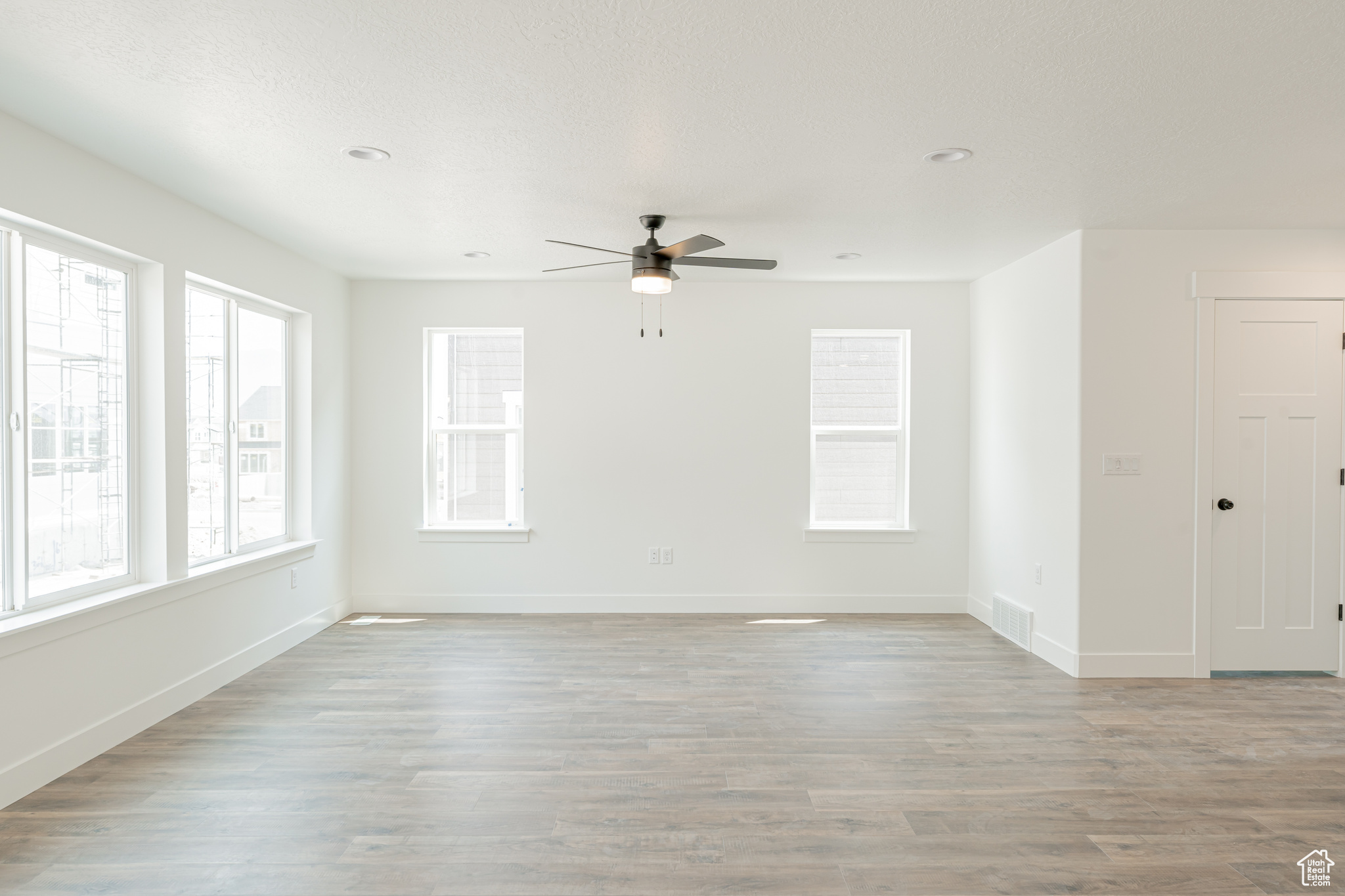 Unfurnished living room featuring light wood-type flooring and ceiling fan