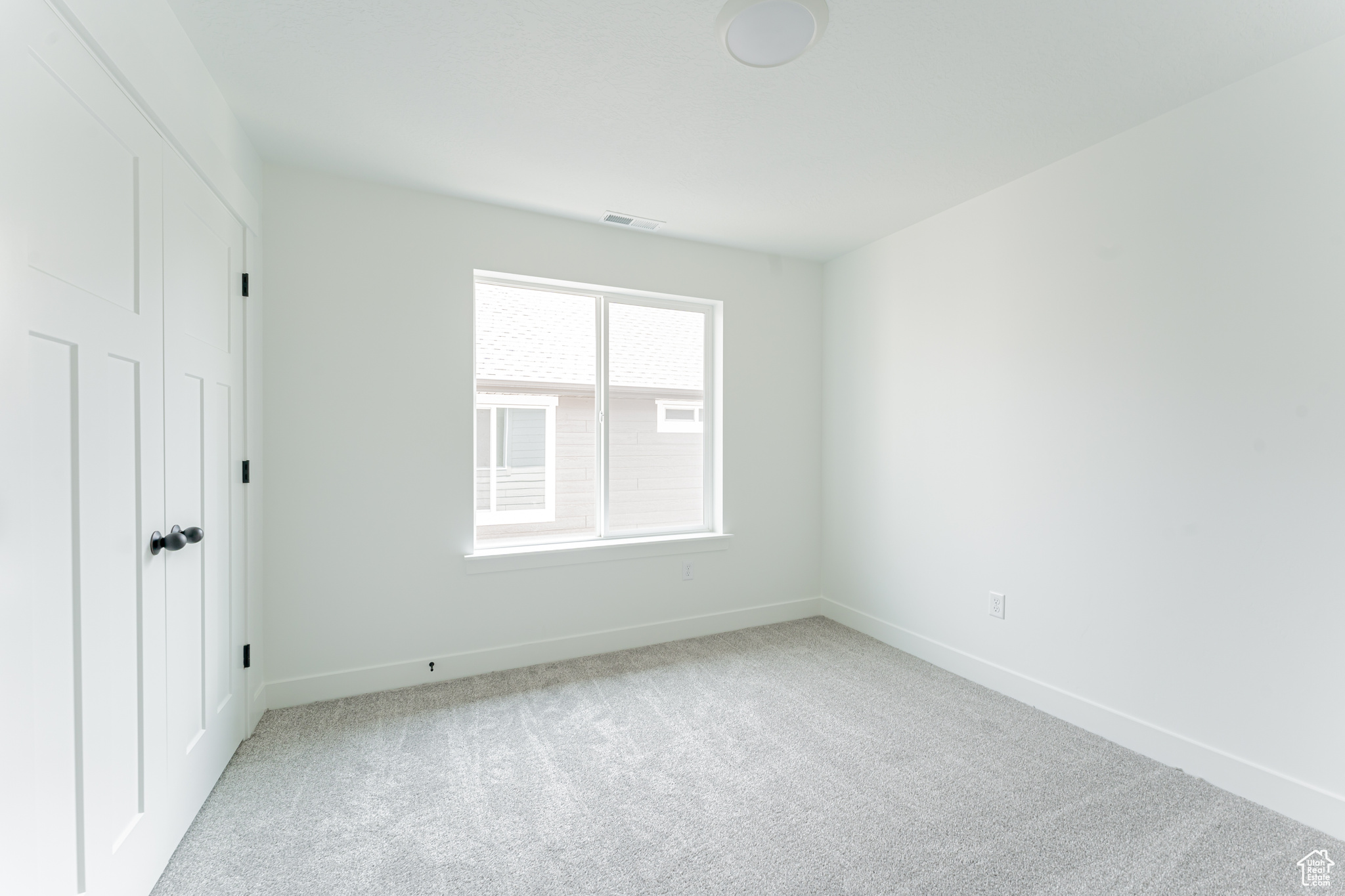 Unfurnished room featuring light colored carpet