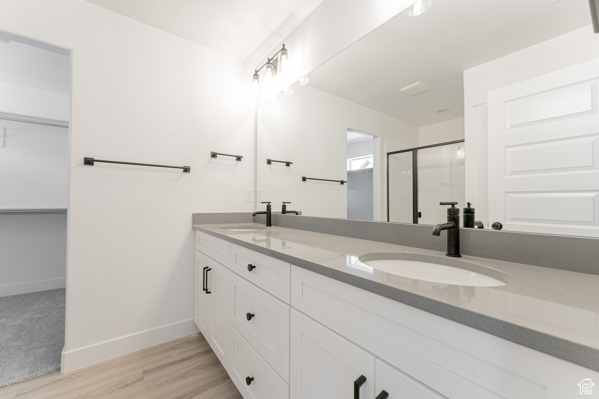 Bathroom with hardwood / wood-style floors and dual bowl vanity