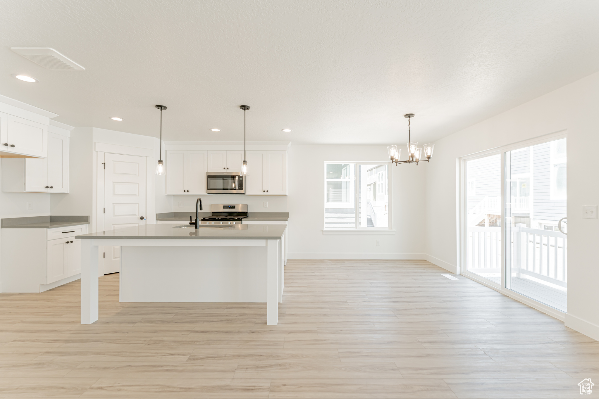 Kitchen featuring light hardwood / wood-style floors, a healthy amount of sunlight, and white cabinets