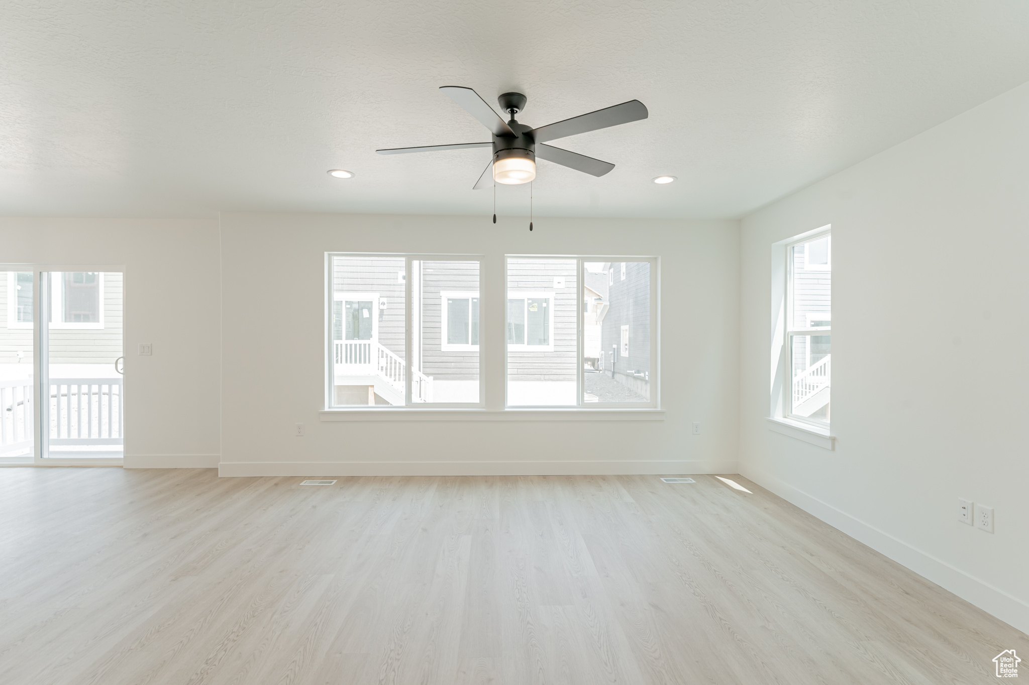 Unfurnished room with light hardwood / wood-style floors and ceiling fan