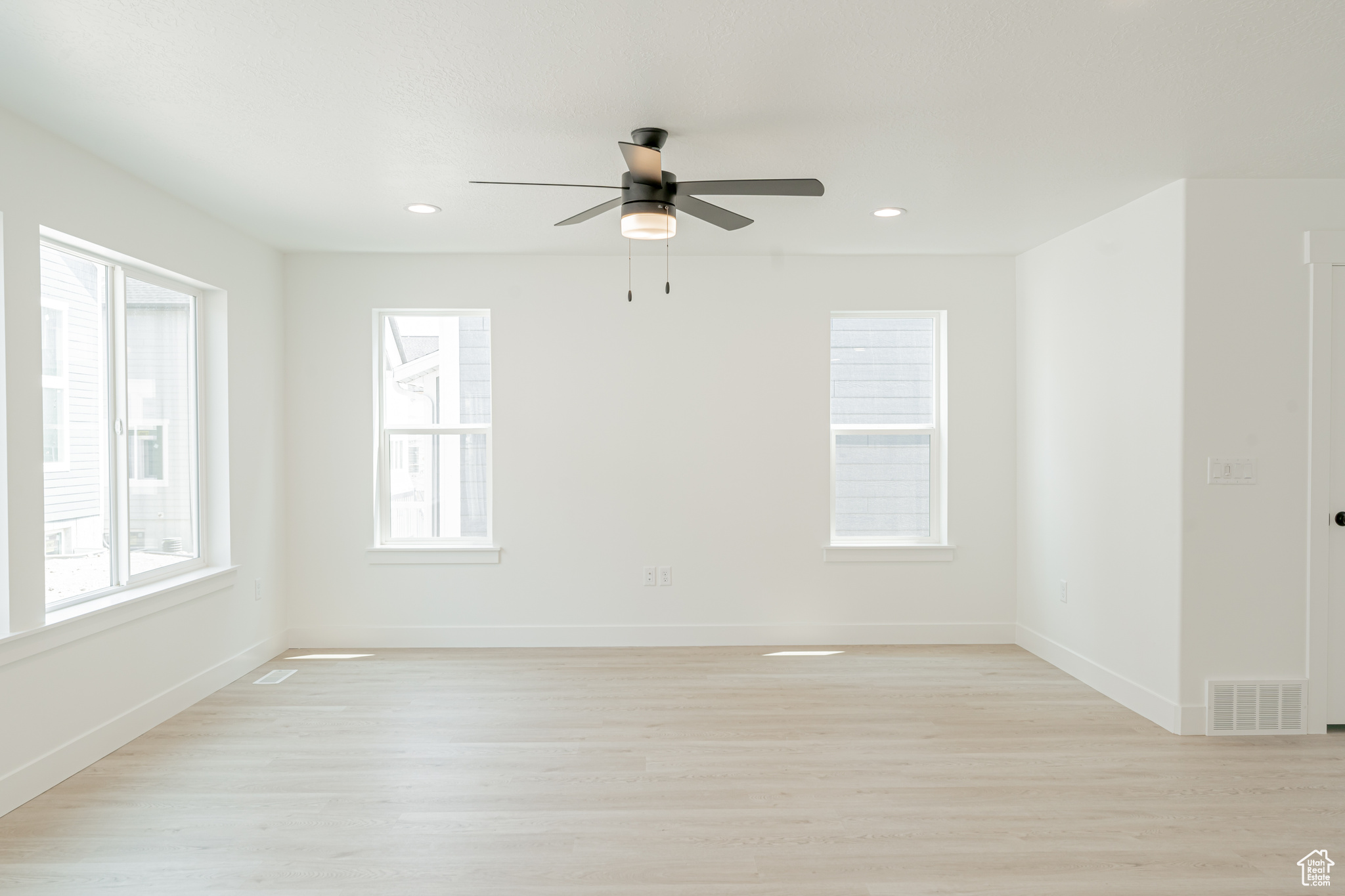 Empty room featuring ceiling fan and light hardwood / wood-style floors