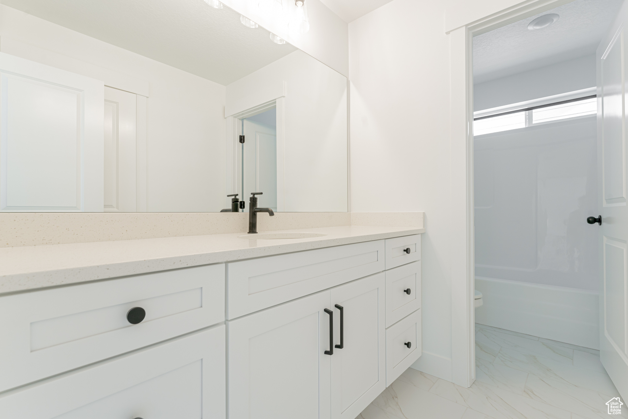 Full bathroom featuring washtub / shower combination, tile patterned floors, toilet, and vanity