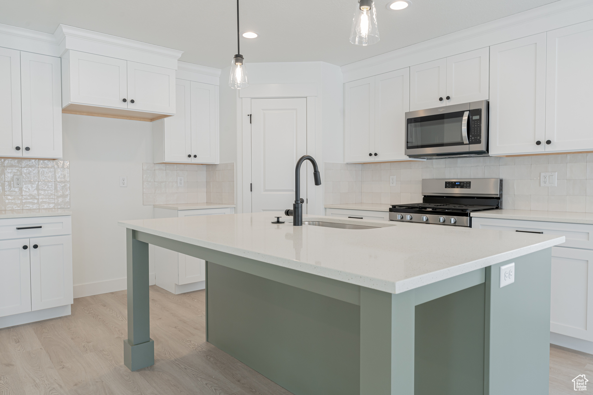 Kitchen with sink, decorative backsplash, an island with sink, and stainless steel appliances