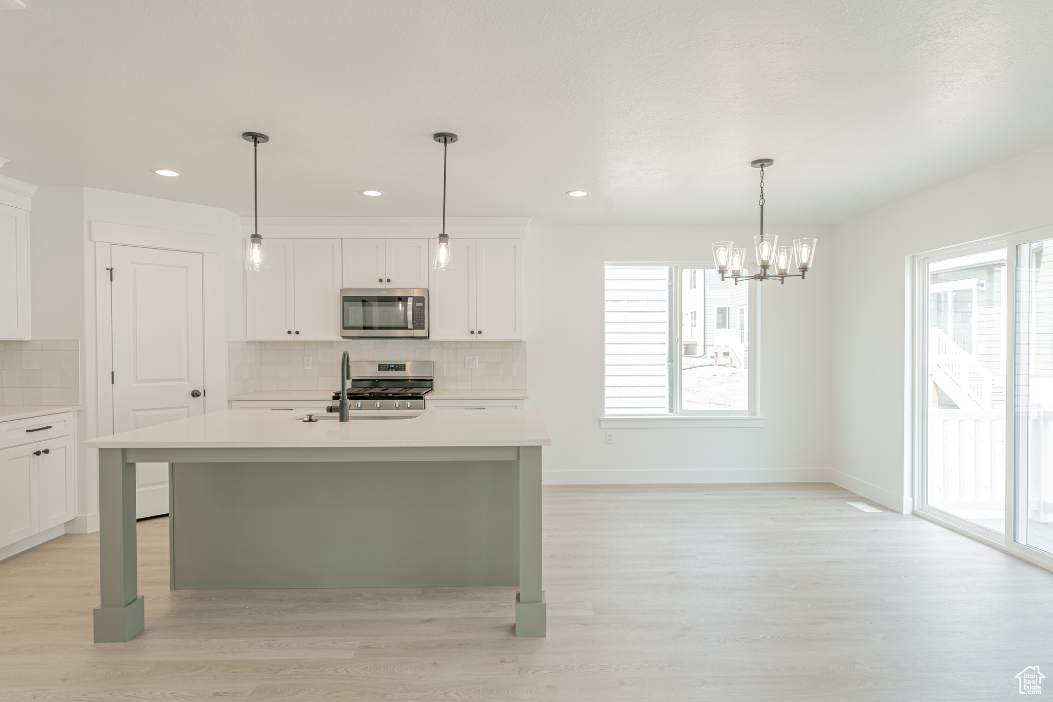 Kitchen featuring backsplash, light wood-type flooring, and stove