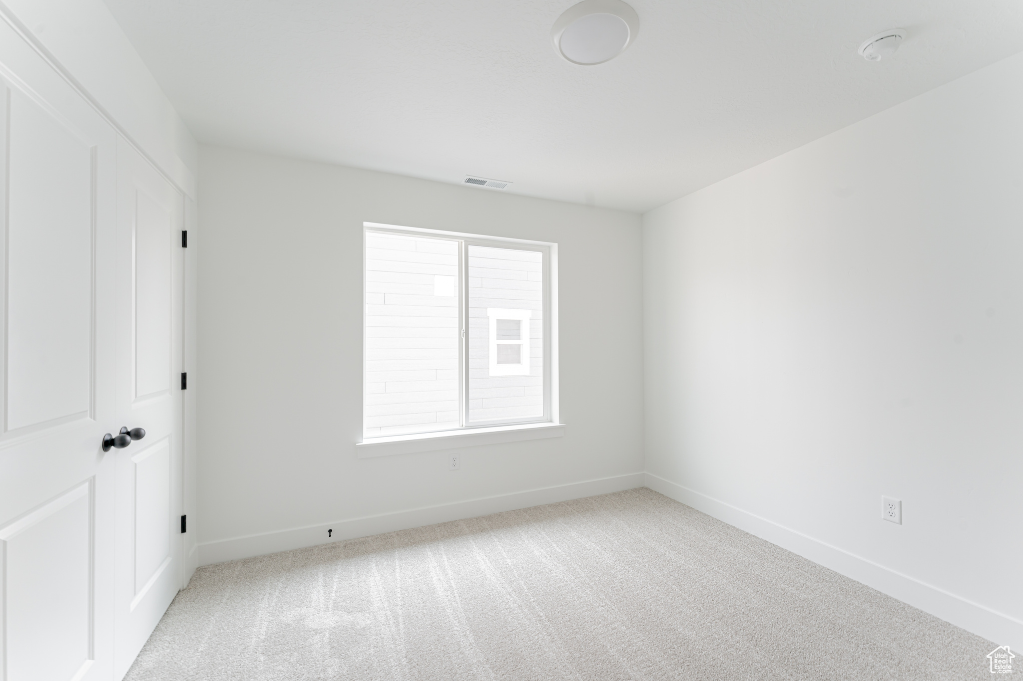 Unfurnished room featuring light colored carpet