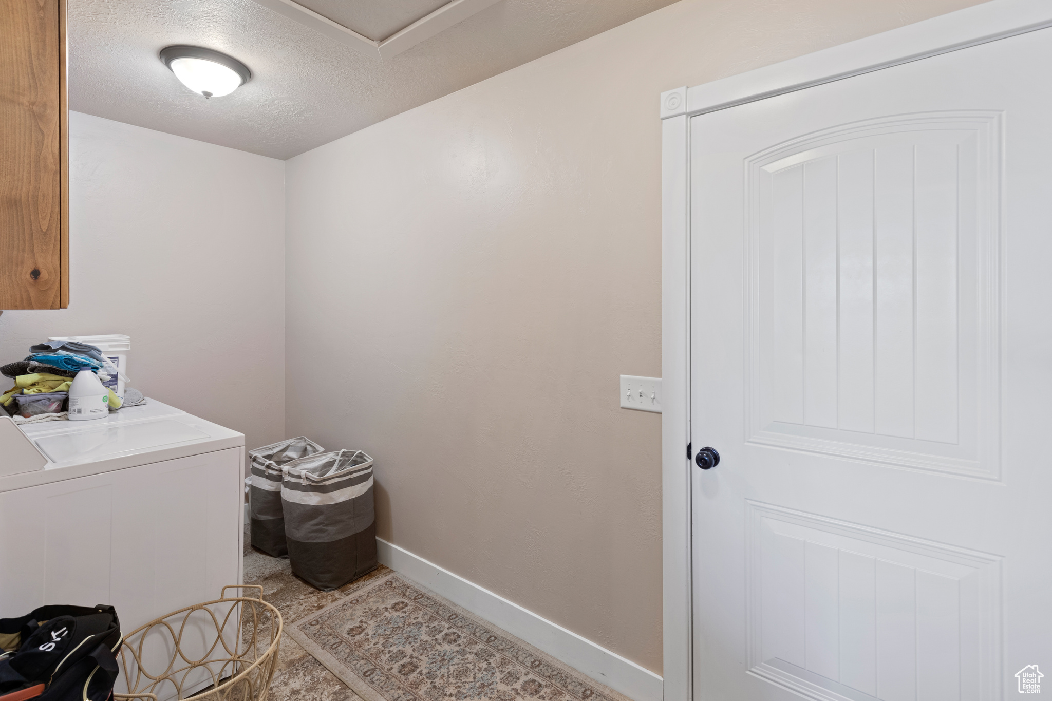 Laundry area featuring light tile floors