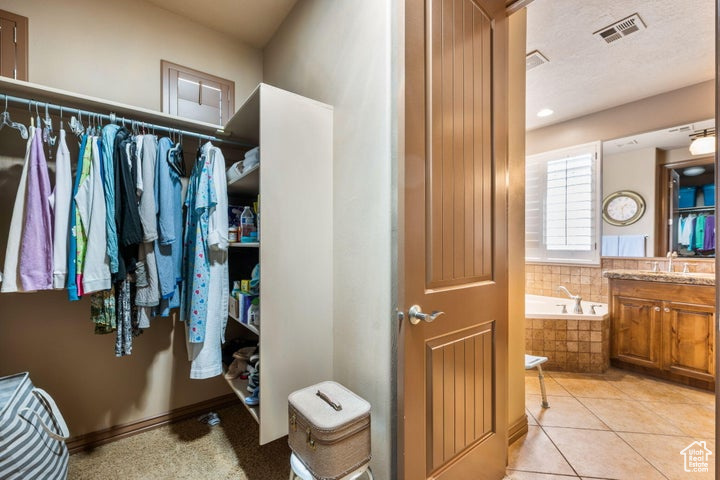 Spacious closet with sink and light tile floors