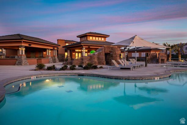 Pool at dusk featuring a patio and a gazebo