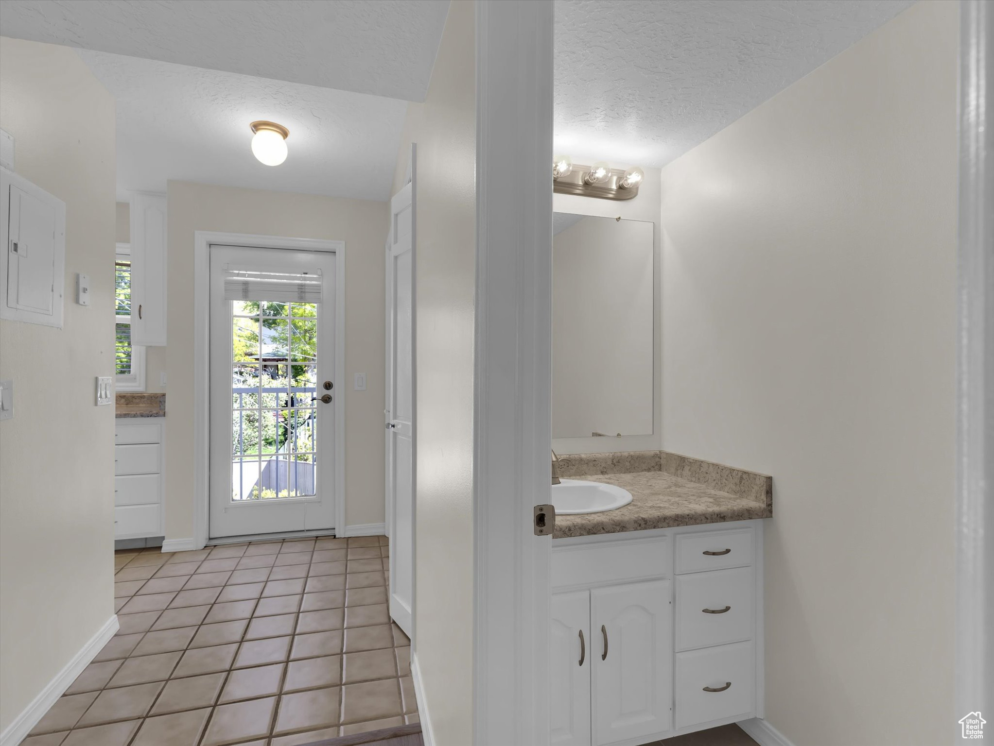 Bathroom featuring tile flooring, a textured ceiling, and large vanity