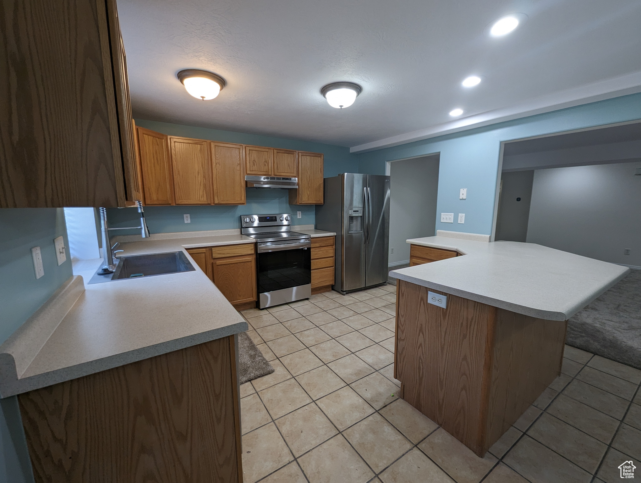 Kitchen with stainless steel appliances, light tile floors, and sink