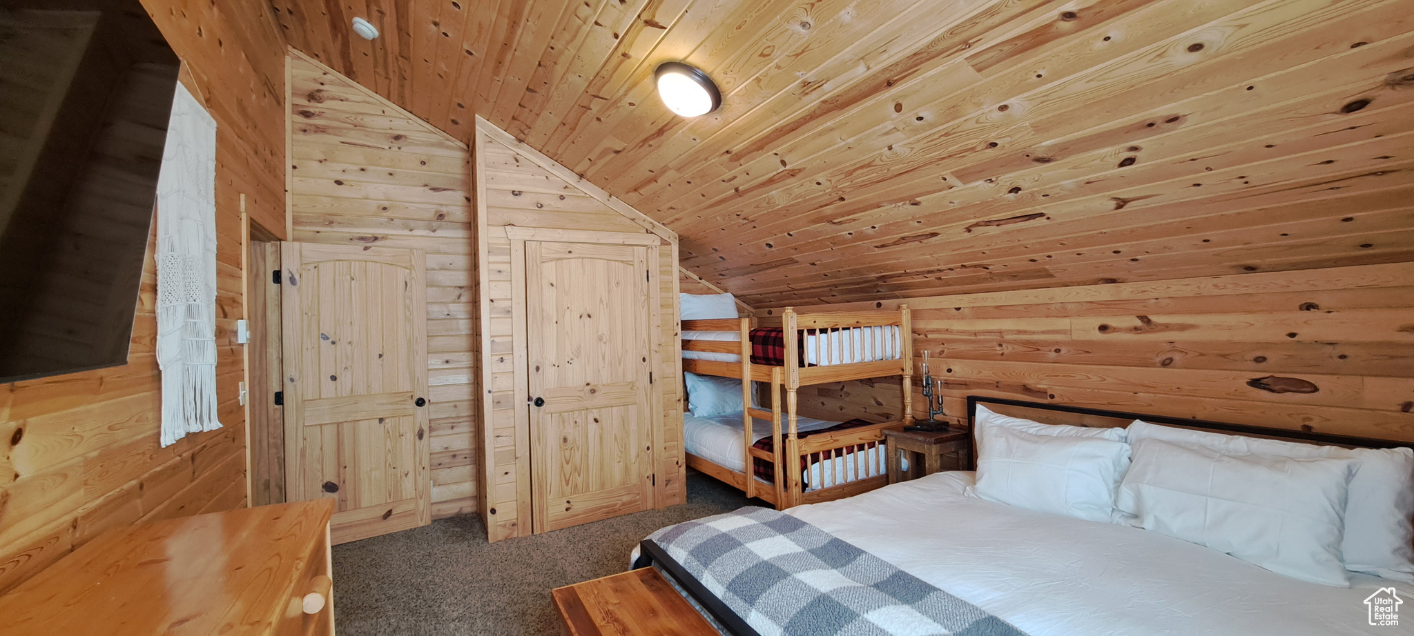 Unfurnished bedroom with wood ceiling, lofted ceiling, and wood walls