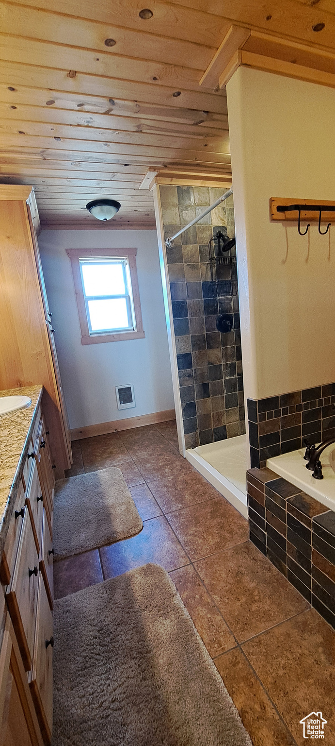 Bathroom featuring tile flooring, vanity, separate shower and tub, and wood ceiling