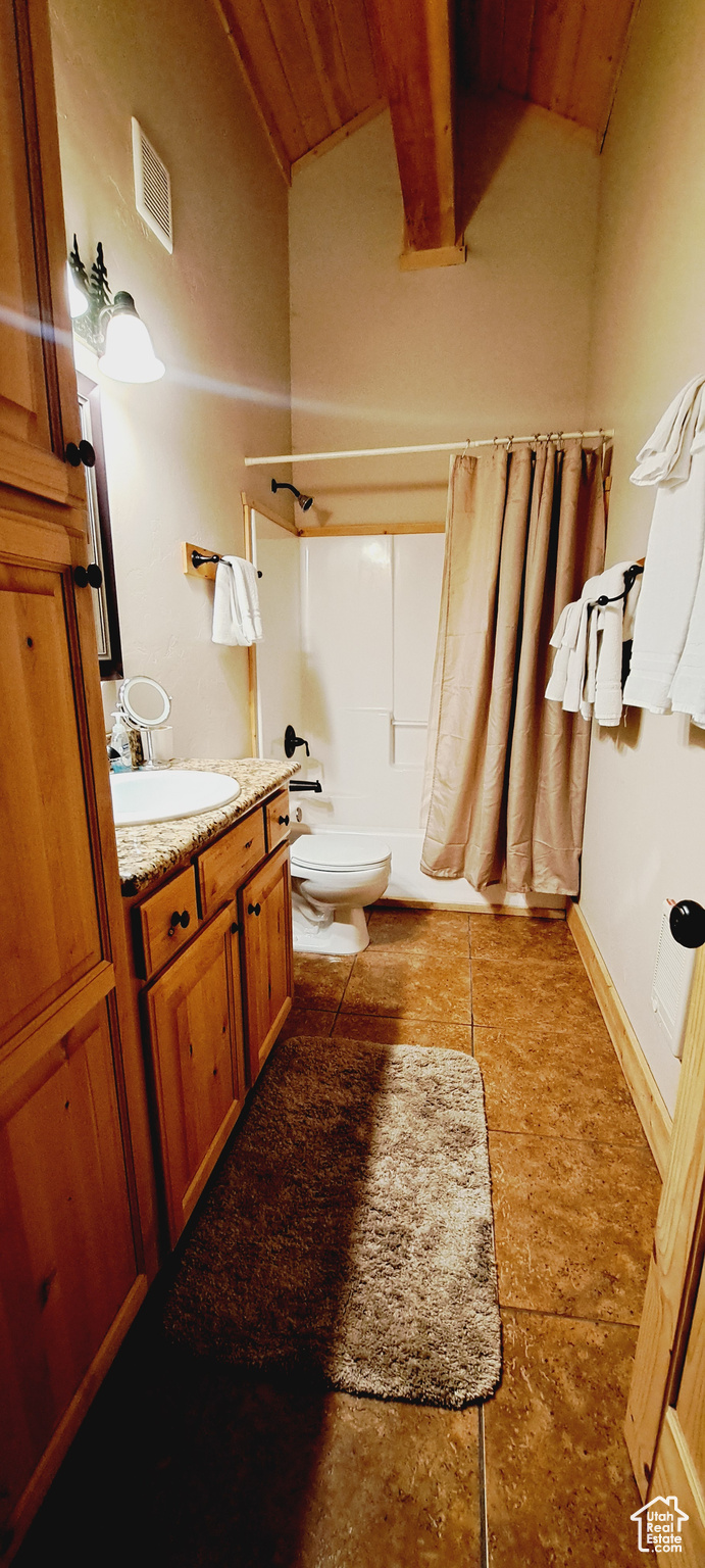 Full bathroom with tile flooring, vanity, shower / bath combo, and toilet