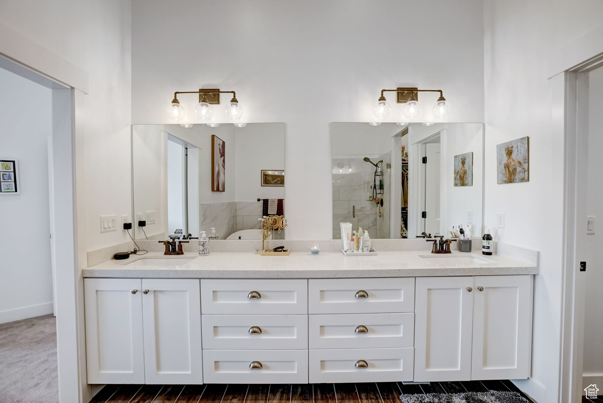 Bathroom featuring a tile shower, double sink, and large vanity