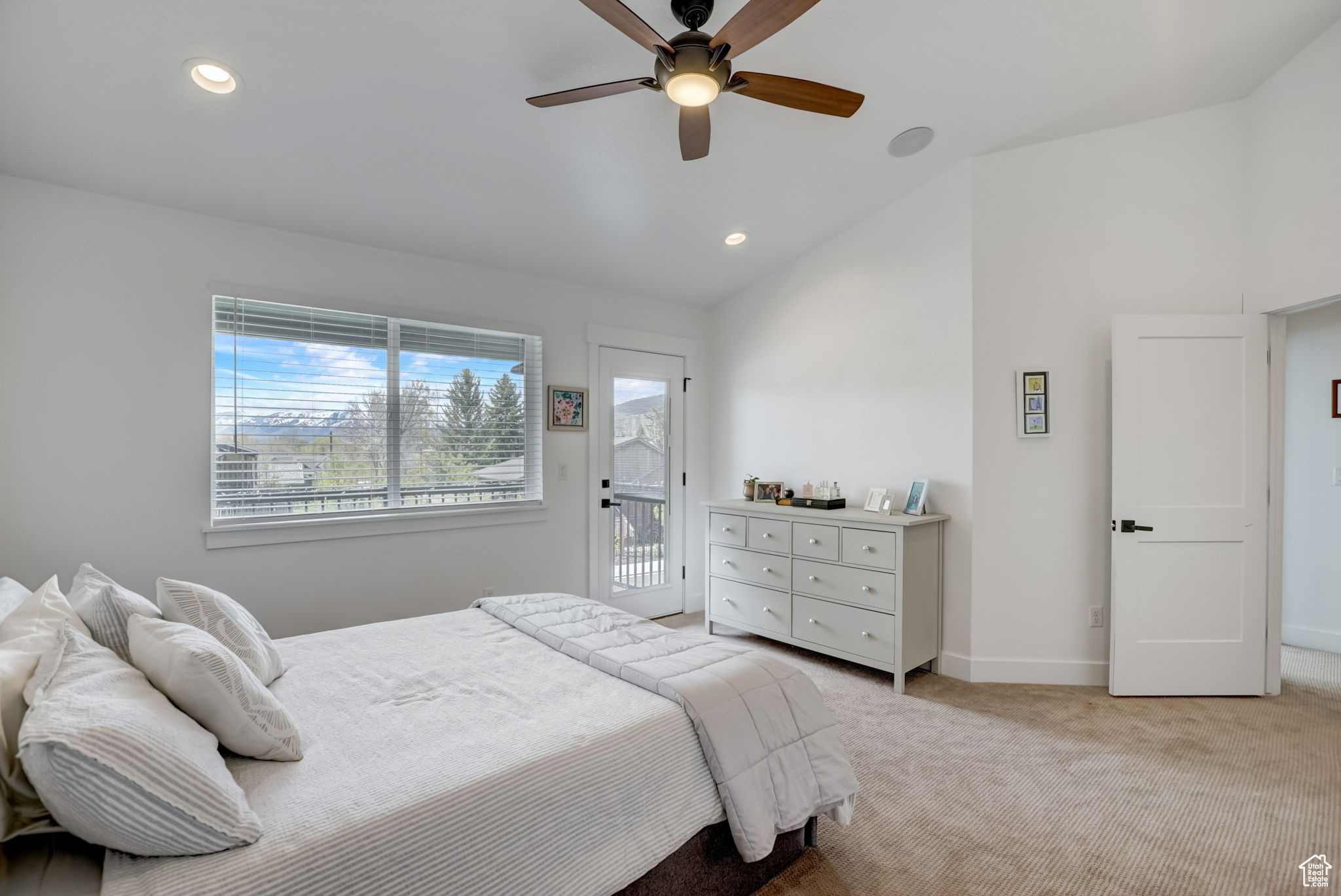 Carpeted bedroom featuring ceiling fan, access to exterior, and lofted ceiling