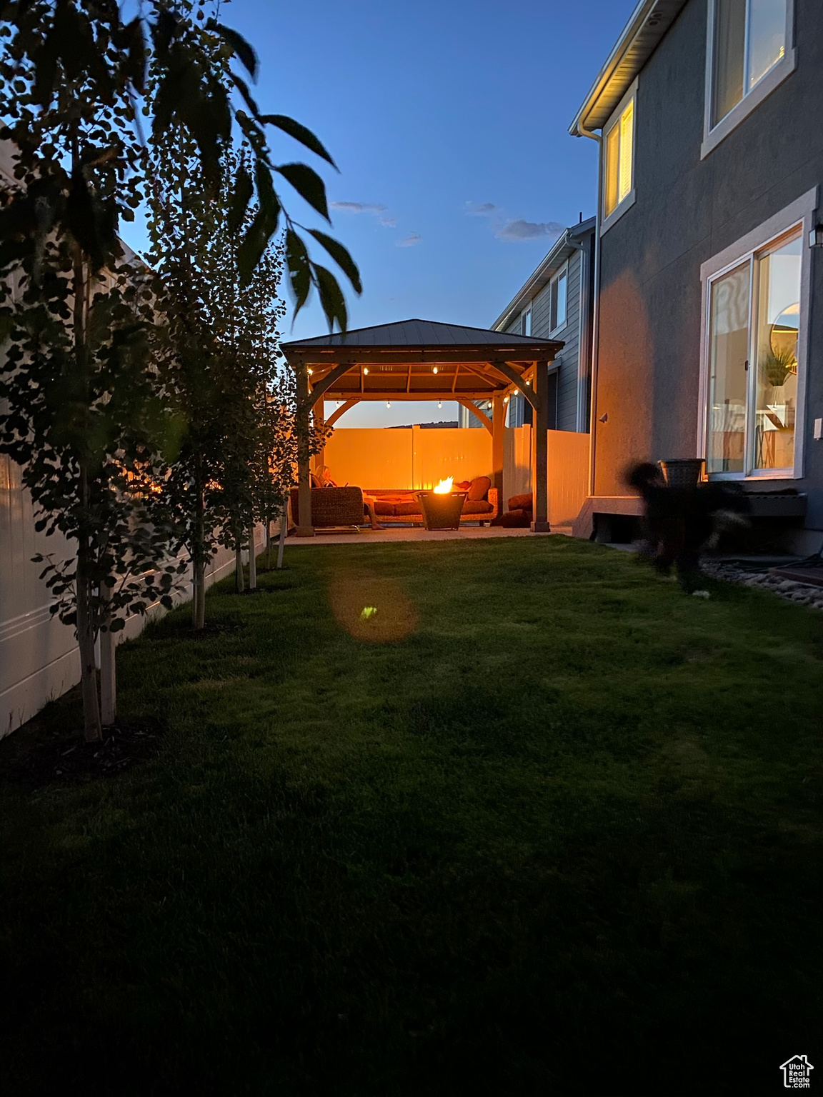 Yard at dusk with a patio and a gazebo