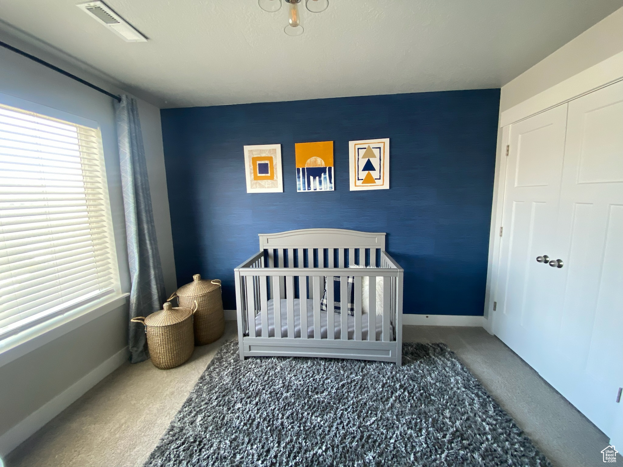 Bedroom featuring carpet and a crib