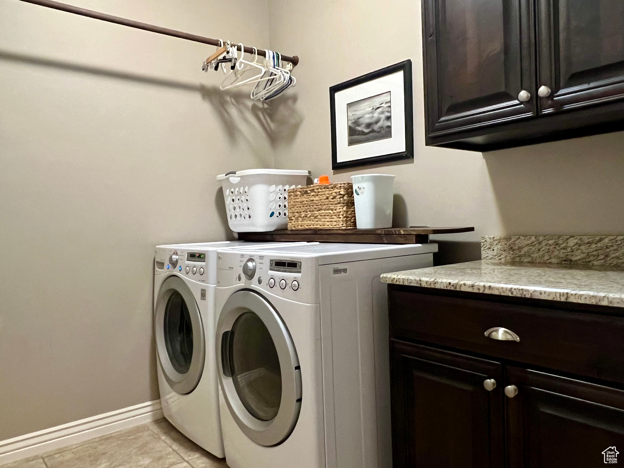 Laundry room featuring cabinets, light tile flooring, and washer and dryer hookups