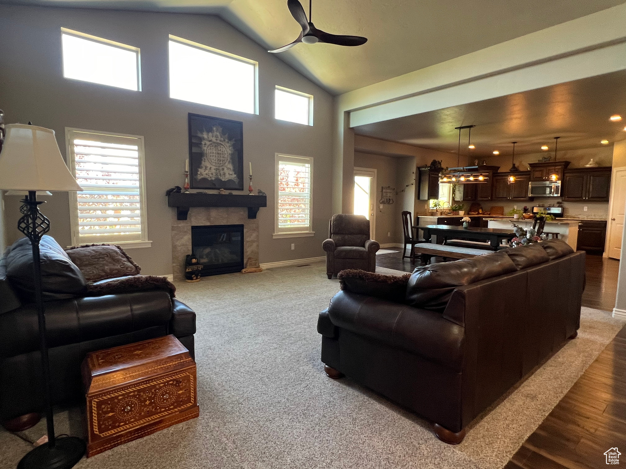Great room featuring a fireplace, ceiling fan, and lofted ceiling