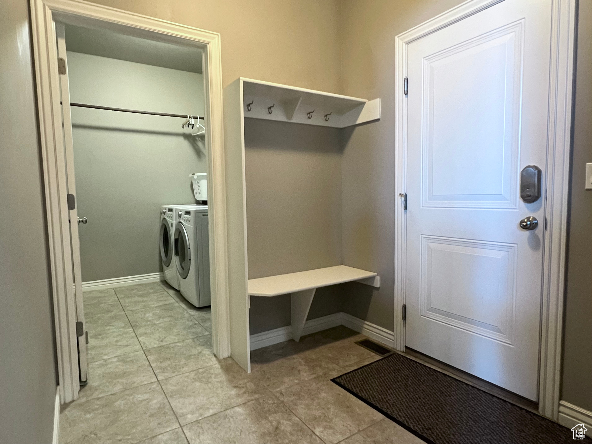 Mudroom featuring washer and clothes dryer and light tile floors