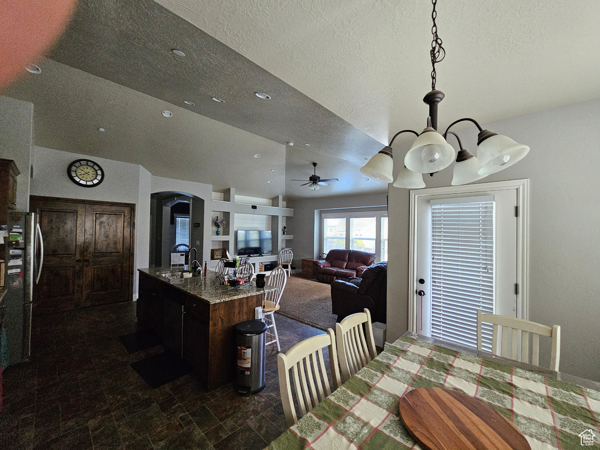 Dining room featuring a textured ceiling, sink, ceiling fan, and dark tile flooring
