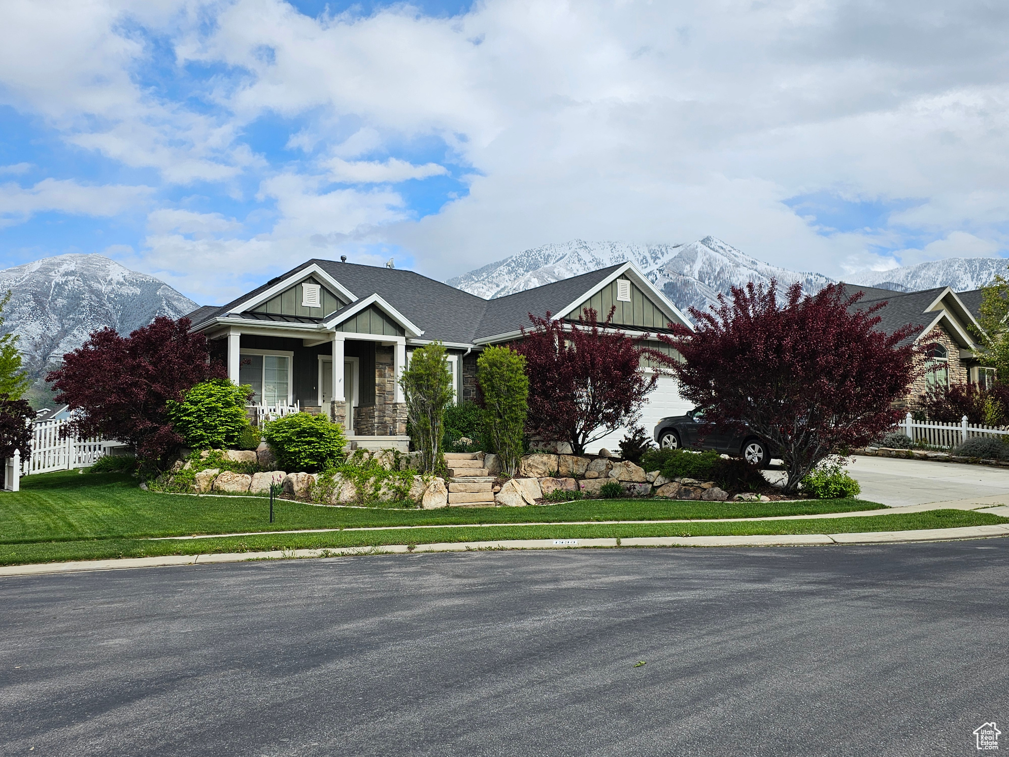 View of front of home with a mountain view, covered porch, and a front lawn