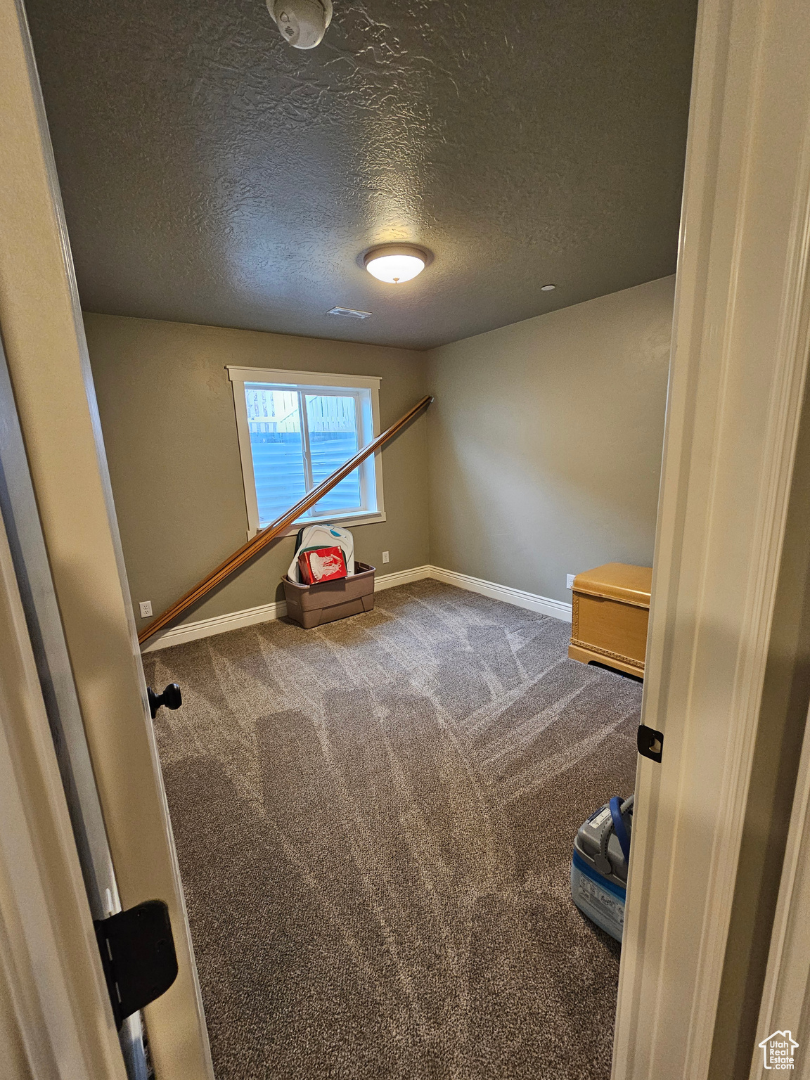 Interior space featuring carpet flooring and a textured ceiling