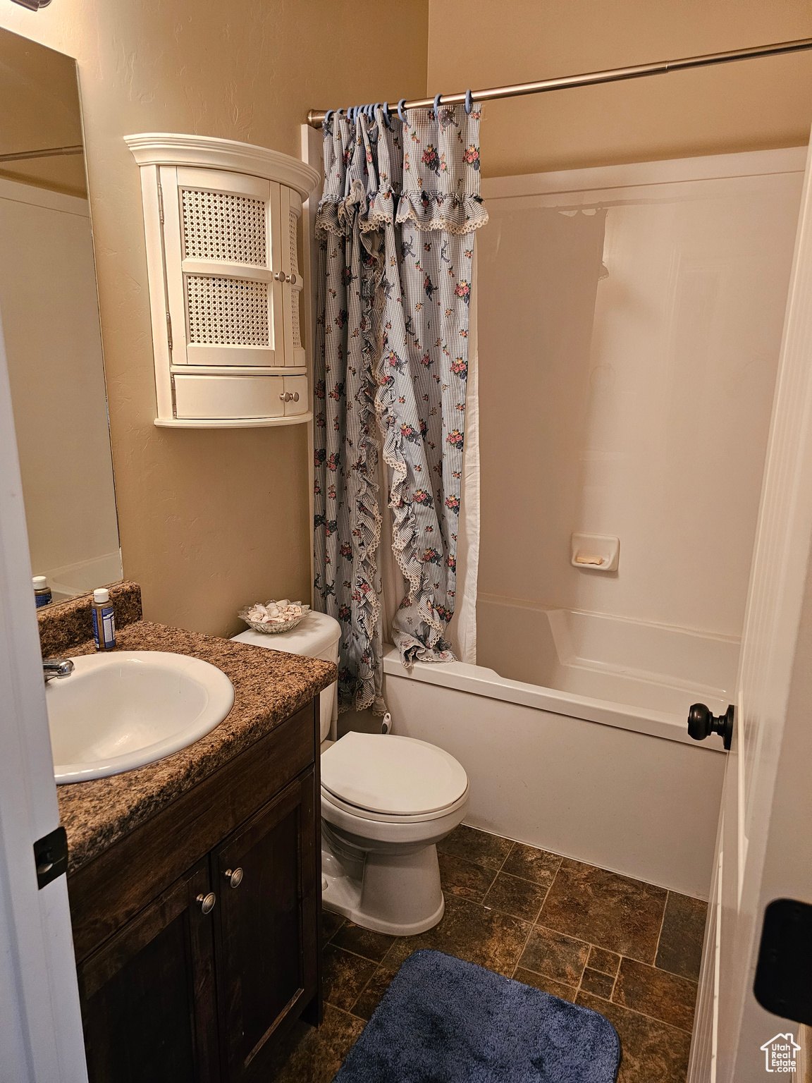 Full bathroom featuring vanity with extensive cabinet space, toilet, tile floors, and shower / bathtub combination with curtain