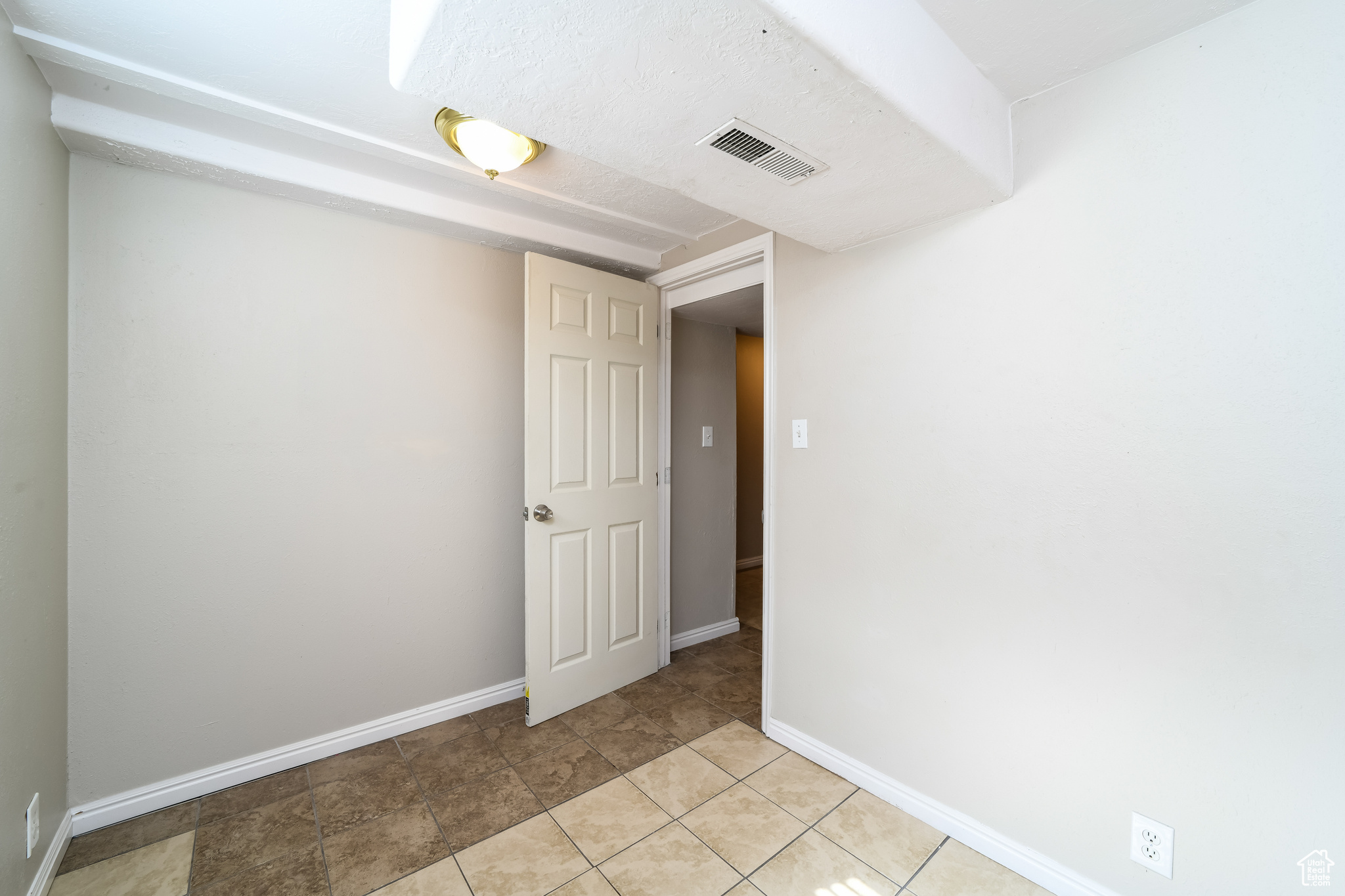 Unfurnished room featuring light tile flooring